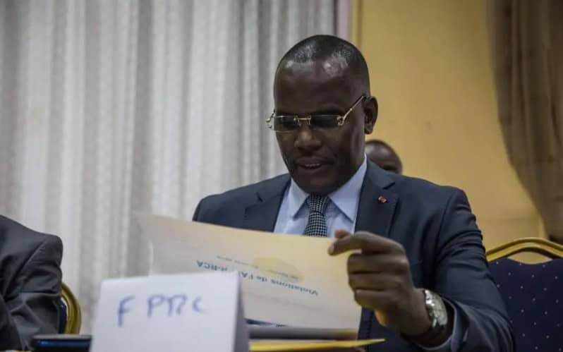 Man reading document during official meeting in Bangui, symbolizing renewed stability efforts.