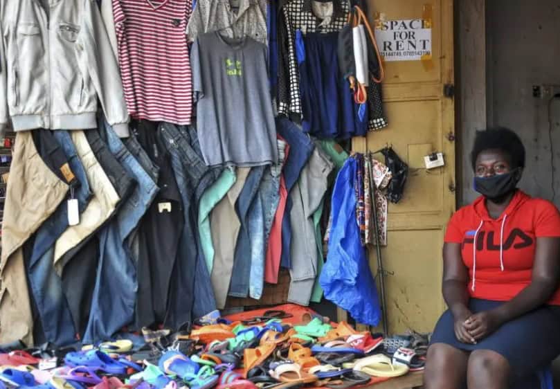 Local clothing stall in Uganda with various garments and shoes for sale.