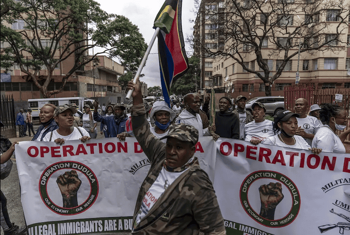 Protesters march holding banners condemning xenophobia and illegal immigration in South Africa.