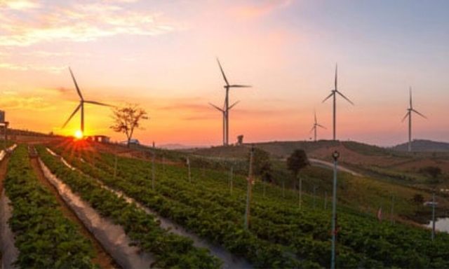 Wind turbines powering rural communities at sunset in Africa.