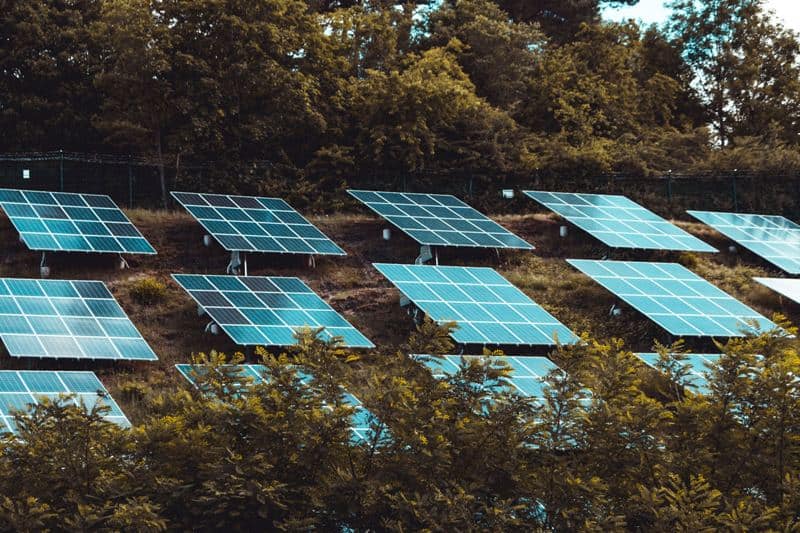 Solar panels on a hillside for renewable energy generation in Africa.