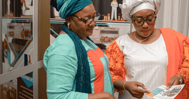 African women entrepreneurs discussing business plans at a networking event.