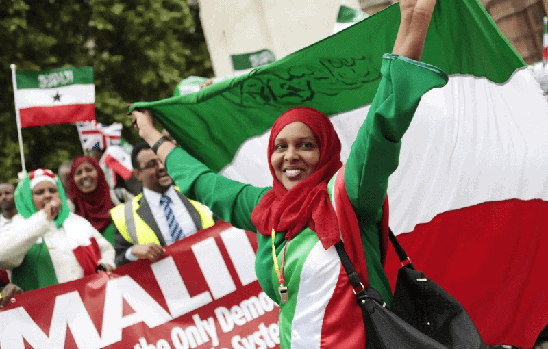 Celebrating Somaliland's resilience with a diverse group holding flags at an international event.