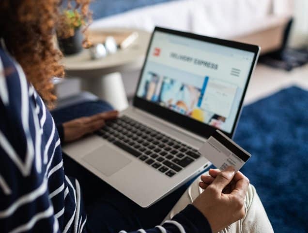 Woman using a credit card and laptop for online banking in Africa.