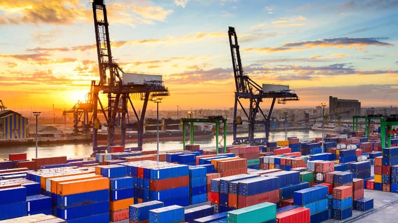 Container port with cargo ships and cranes during sunset, symbolizing African trade growth.