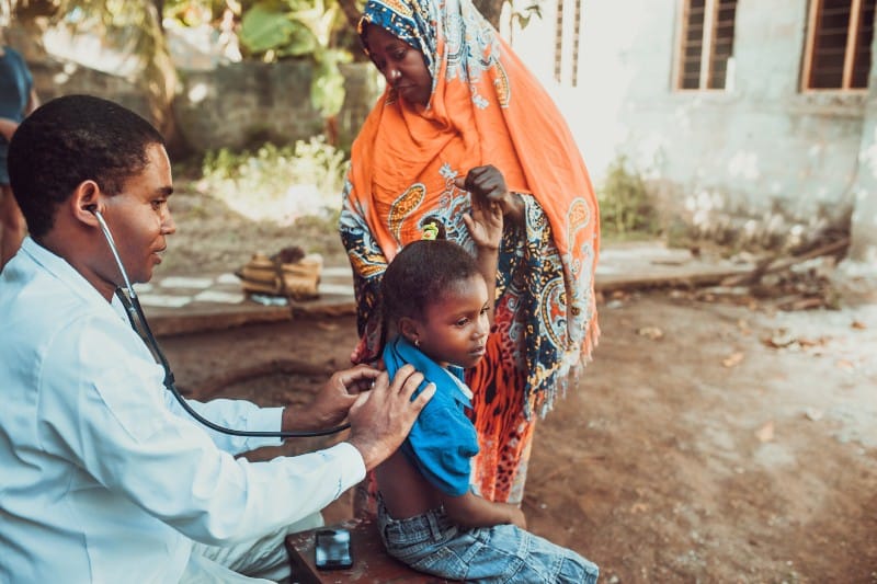 Healthcare worker examines a child in Rwanda for infectious diseases.
