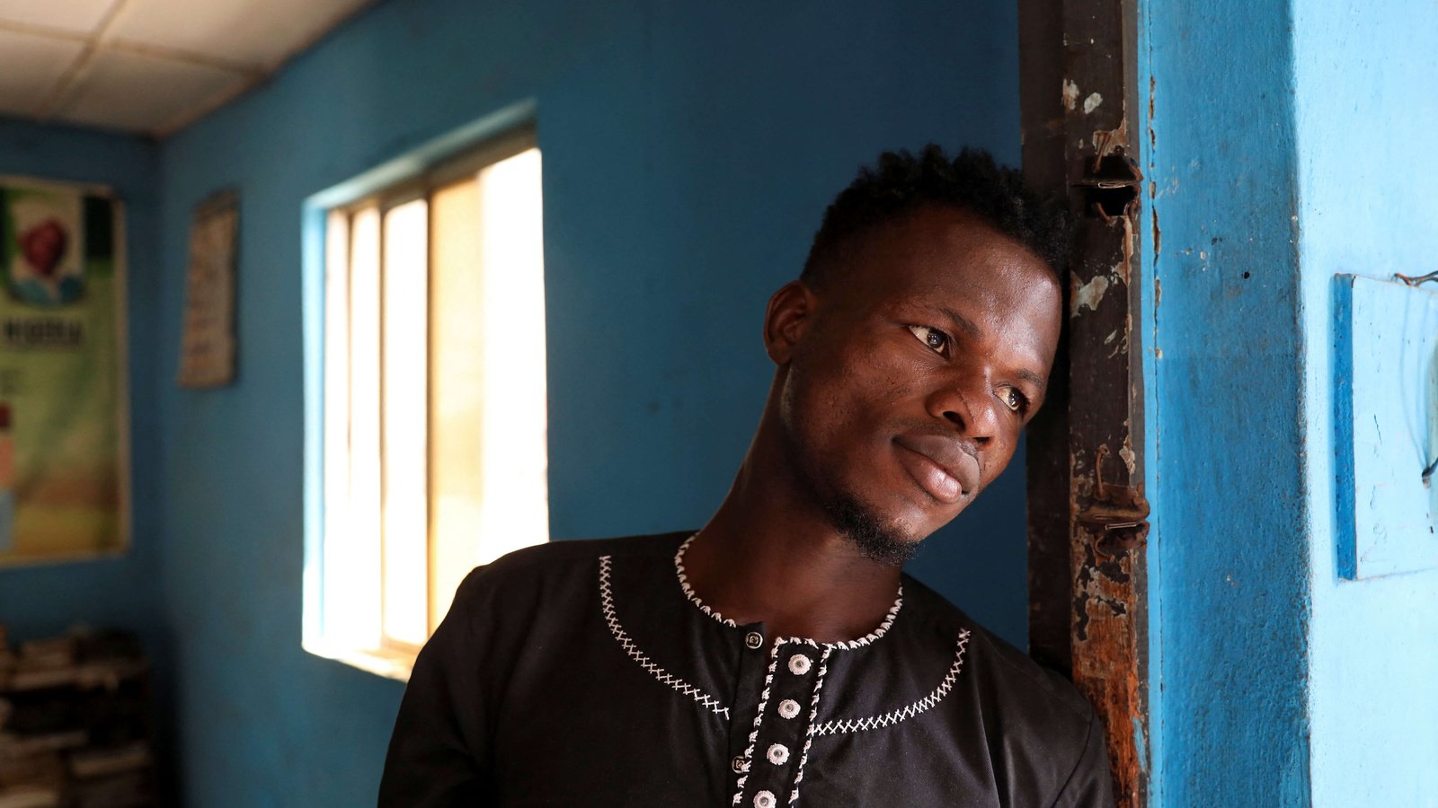 African man in modest home experiencing hardship and lack of resources.