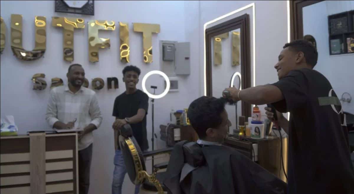 Barber giving a haircut to a client in a stylish barbershop setting.