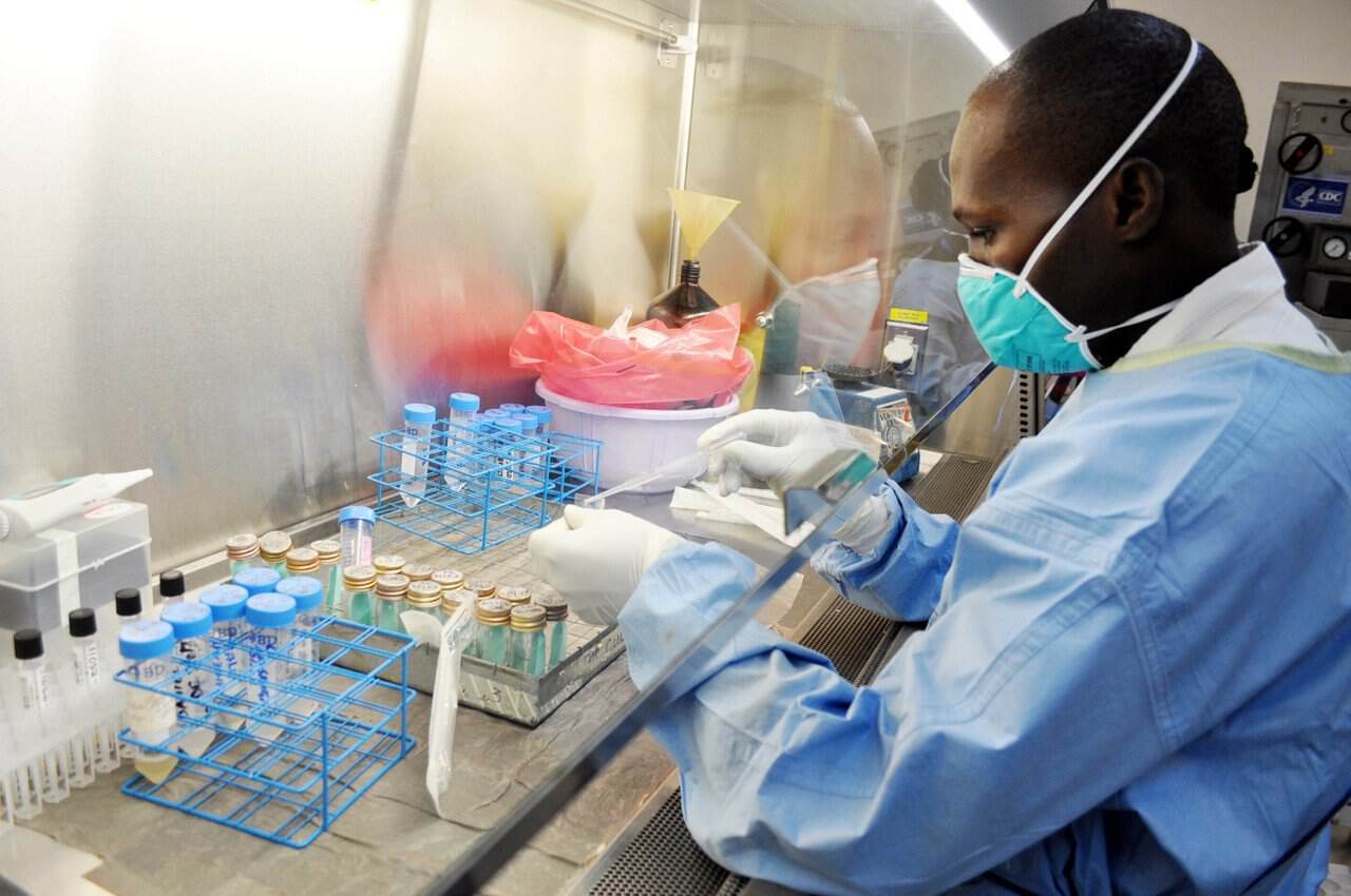African scientist working in a lab to combat drug-resistant tuberculosis using genomics.