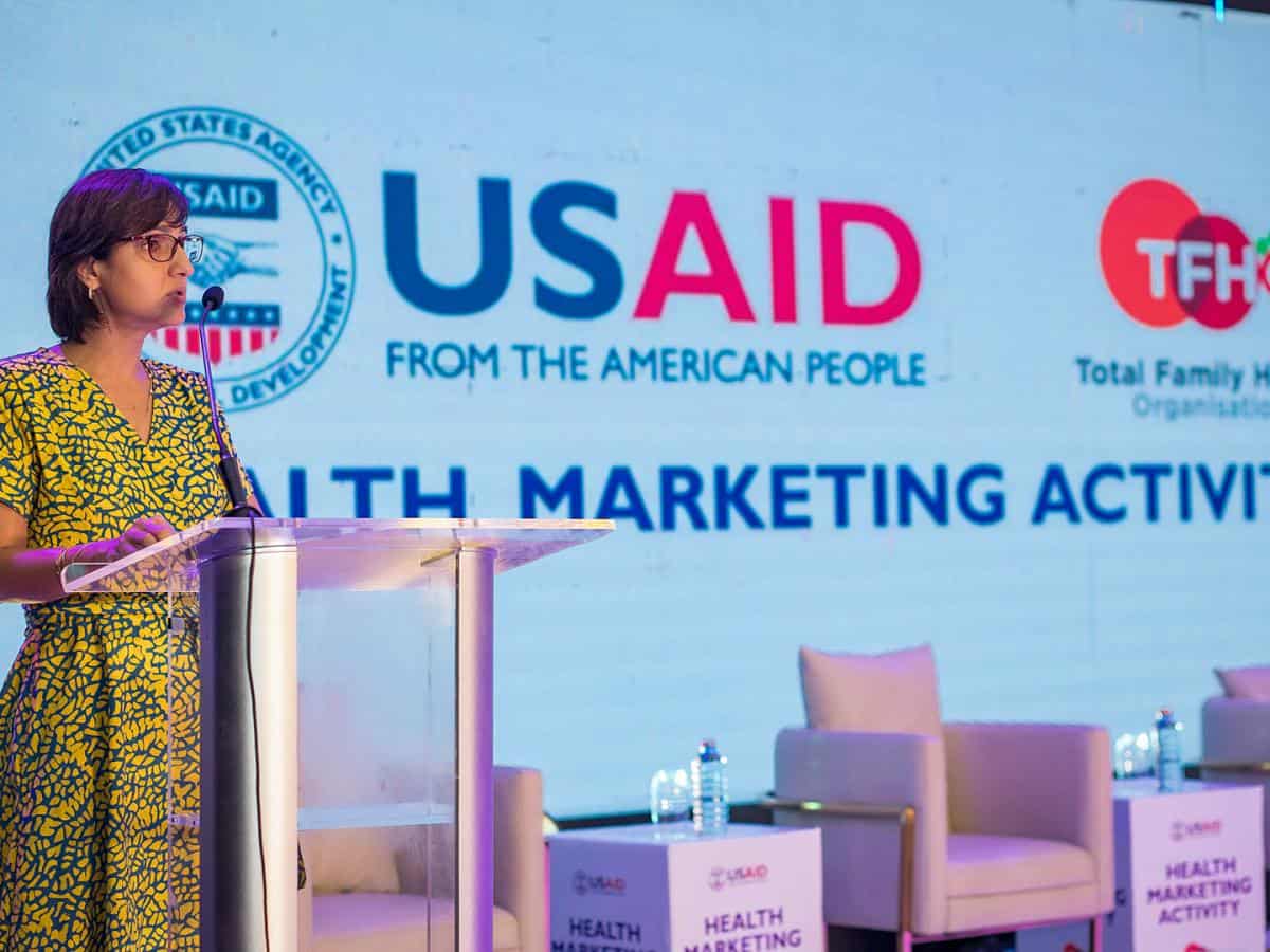 Ghanaian woman speaking at health marketing event supported by USAID.