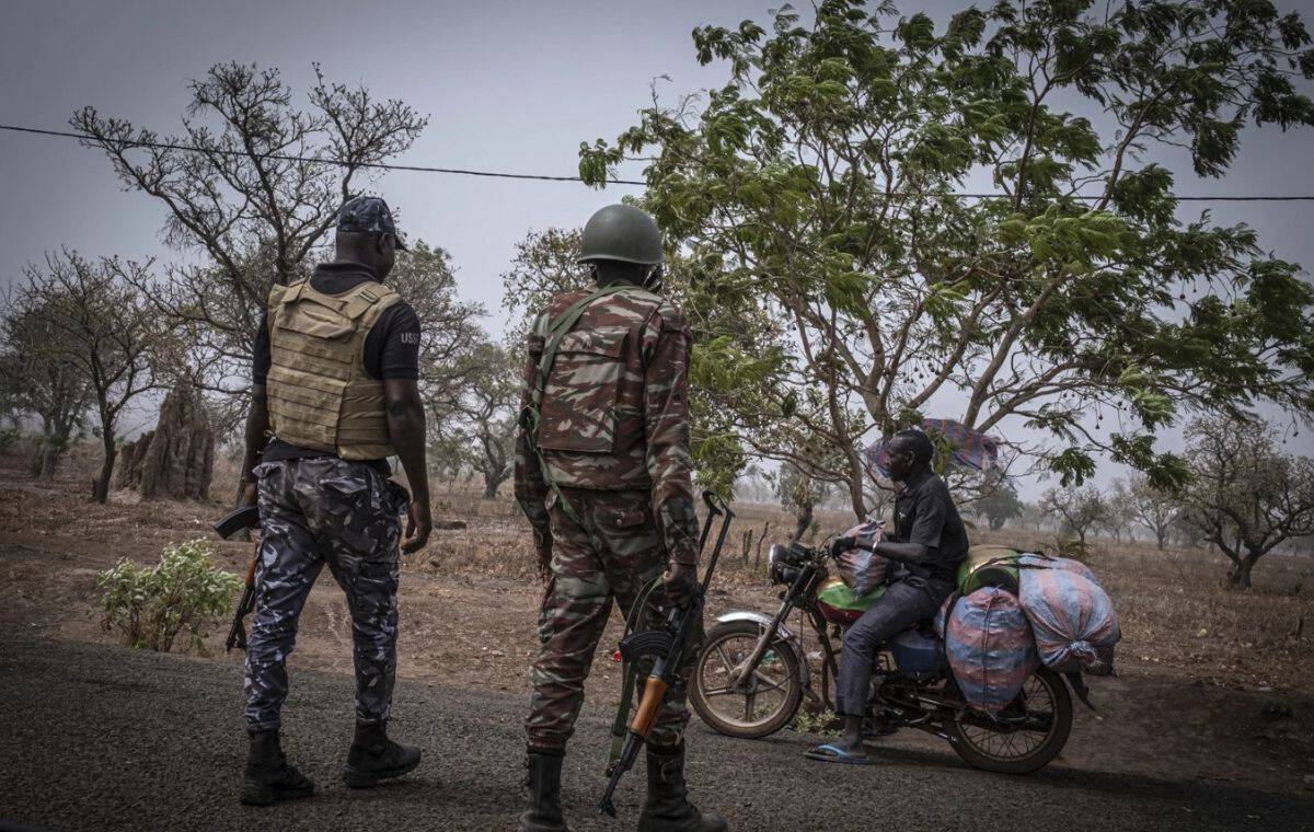 Security officers monitoring a motorcyclist in a rural area of Mauritius.