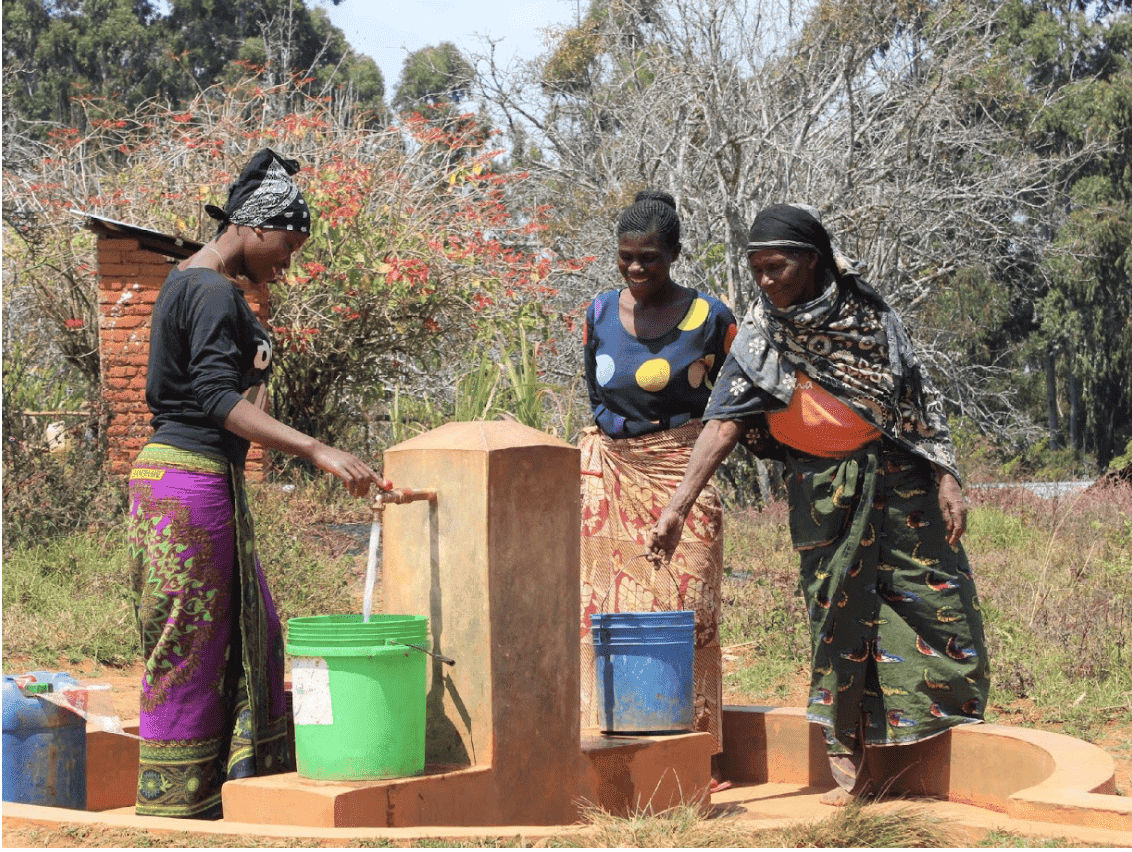 Women collecting water from a community water point in Tanzania.