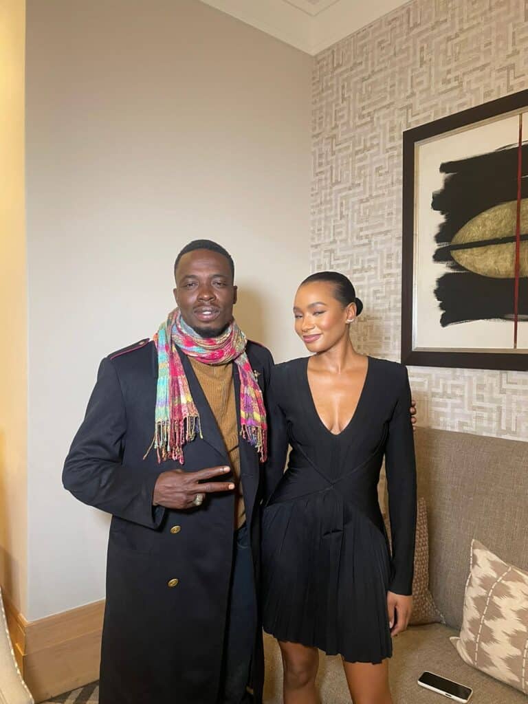 Elegant woman and man dressed in formal attire at an indoor event.