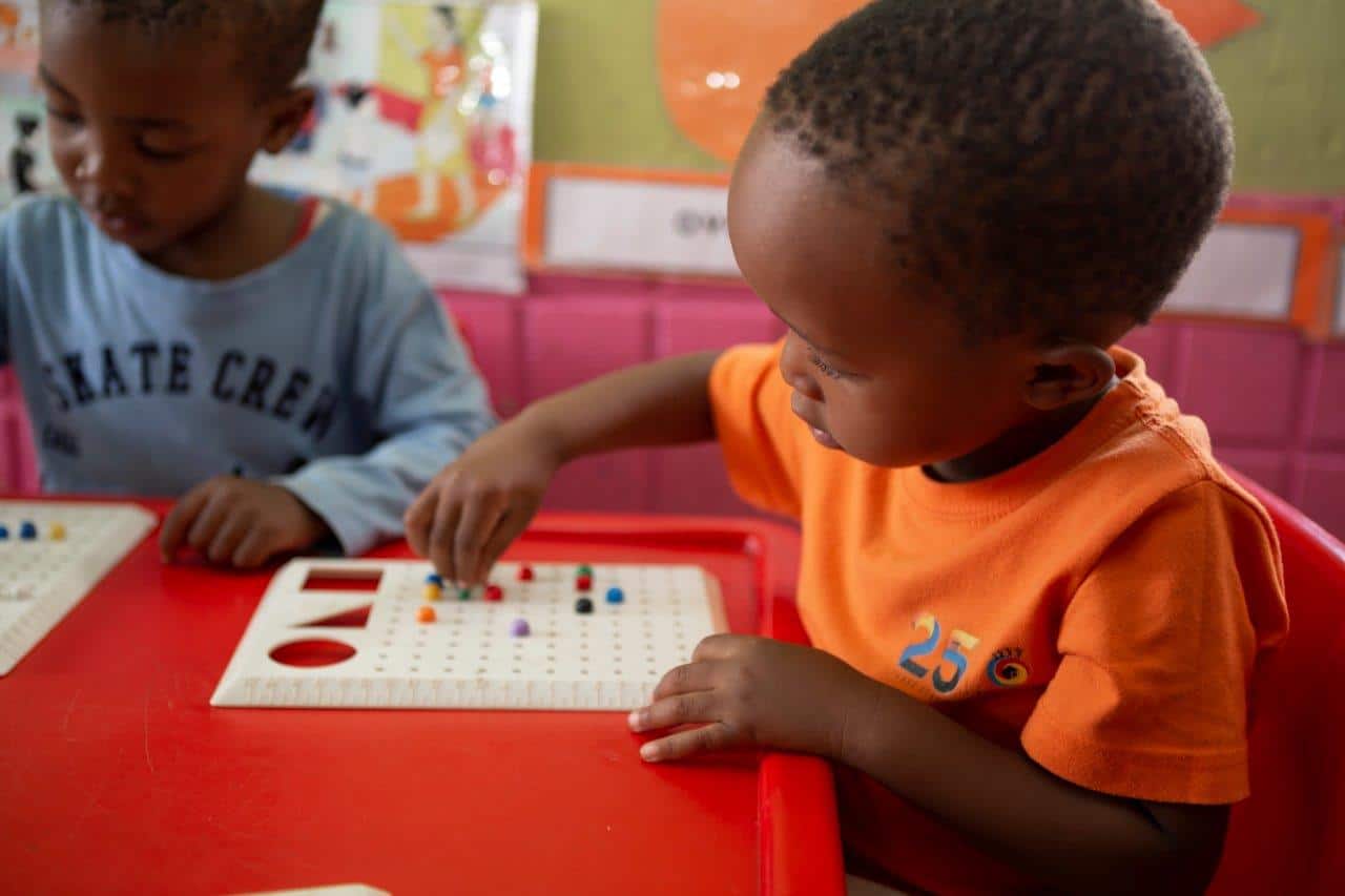 Young children engaging with educational games in a South African classroom.