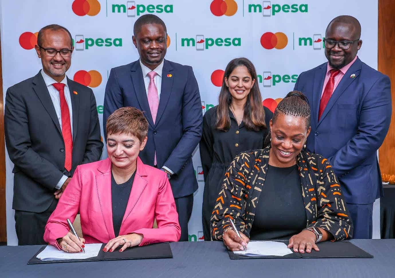 Safaricom and Mastercard executives signing partnership agreement in Kenya.