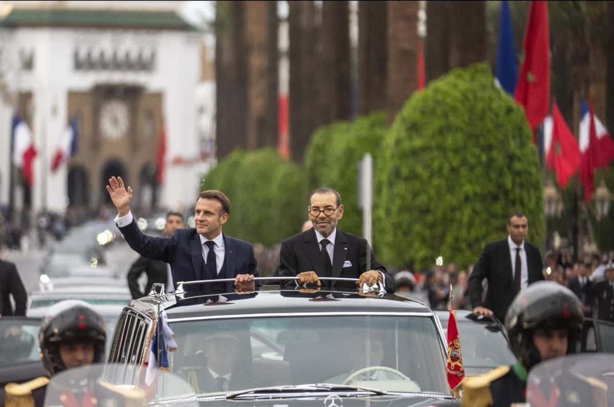 Egyptian officials wave from a convertible car during a diplomatic event.