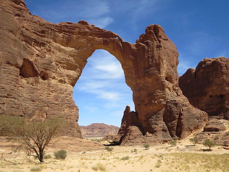 Natural rock arch in Kenyan desert landscape.