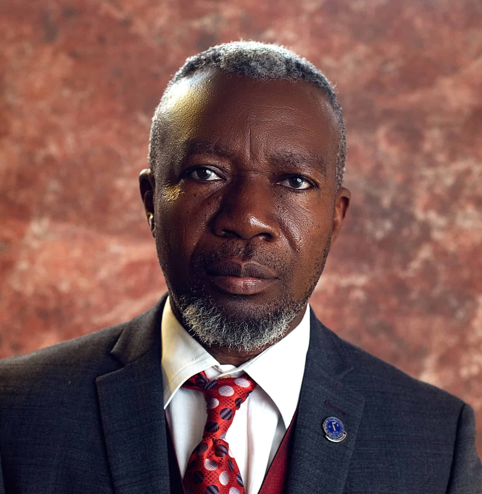 African man in formal attire, representing leadership in global health equity initiatives.
