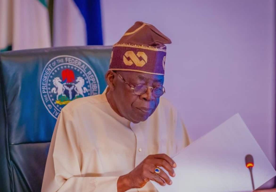 Nigerian official reviewing documents on fuel subsidy reduction impact.