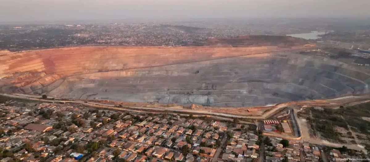 Open-pit cobalt mine in Africa with surrounding urban area and infrastructure.