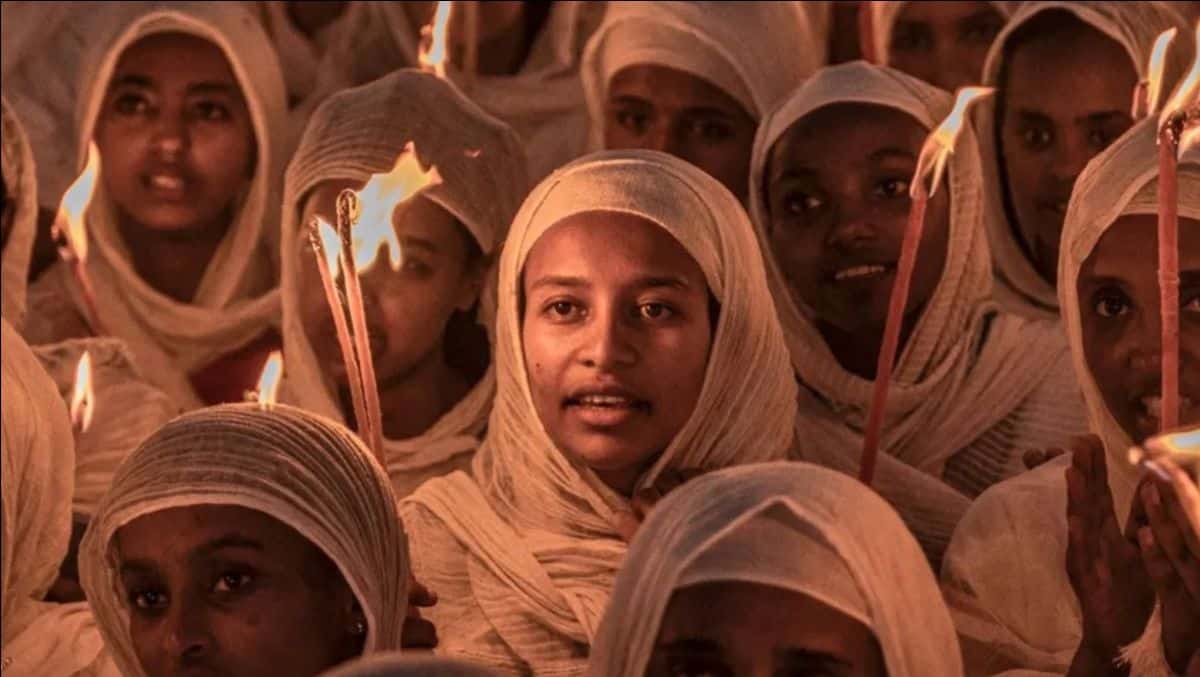 Young girls holding candles during a cultural festival in Africa.