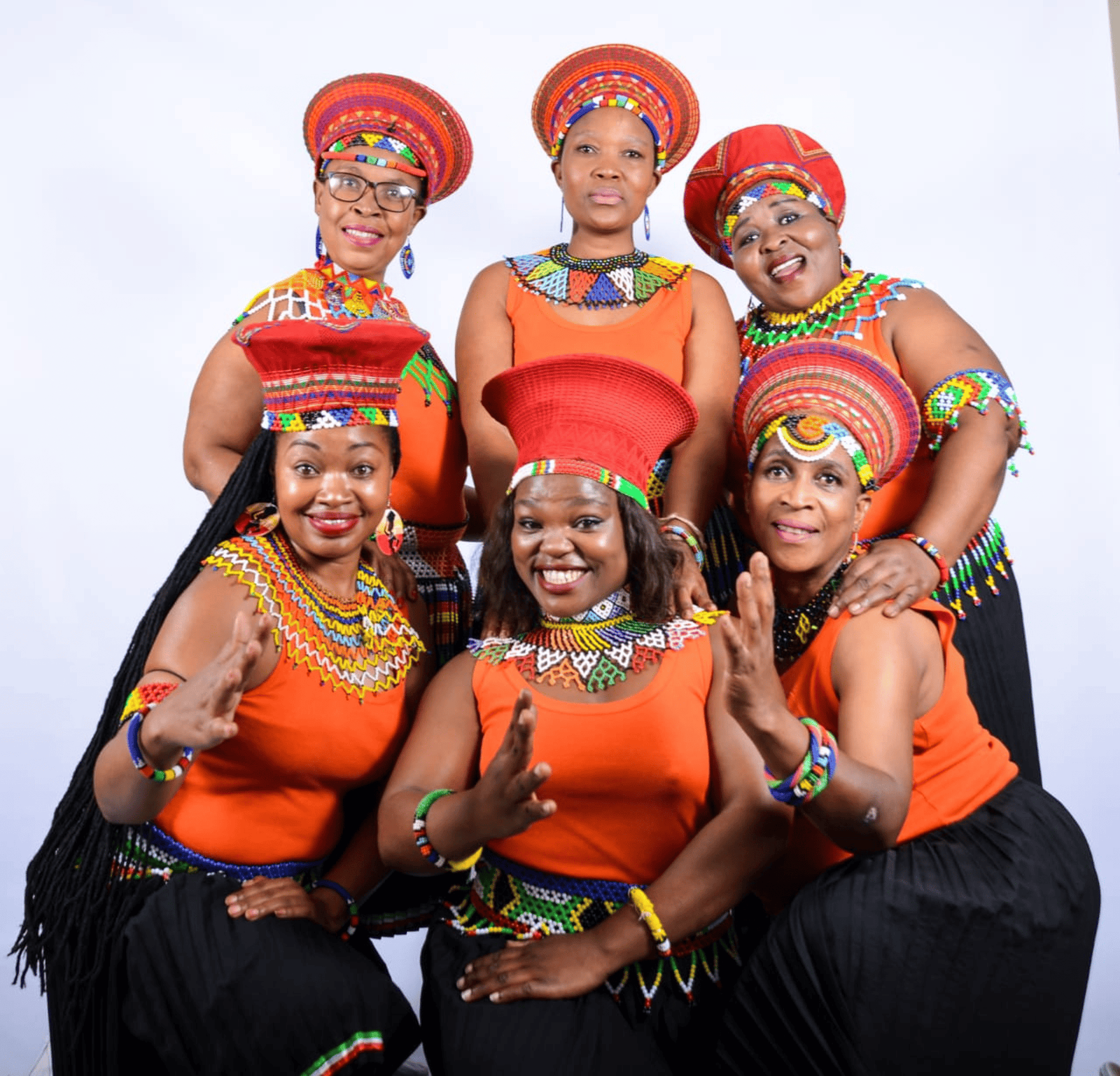 African women in colorful traditional attire celebrating Christmas through song and dance.