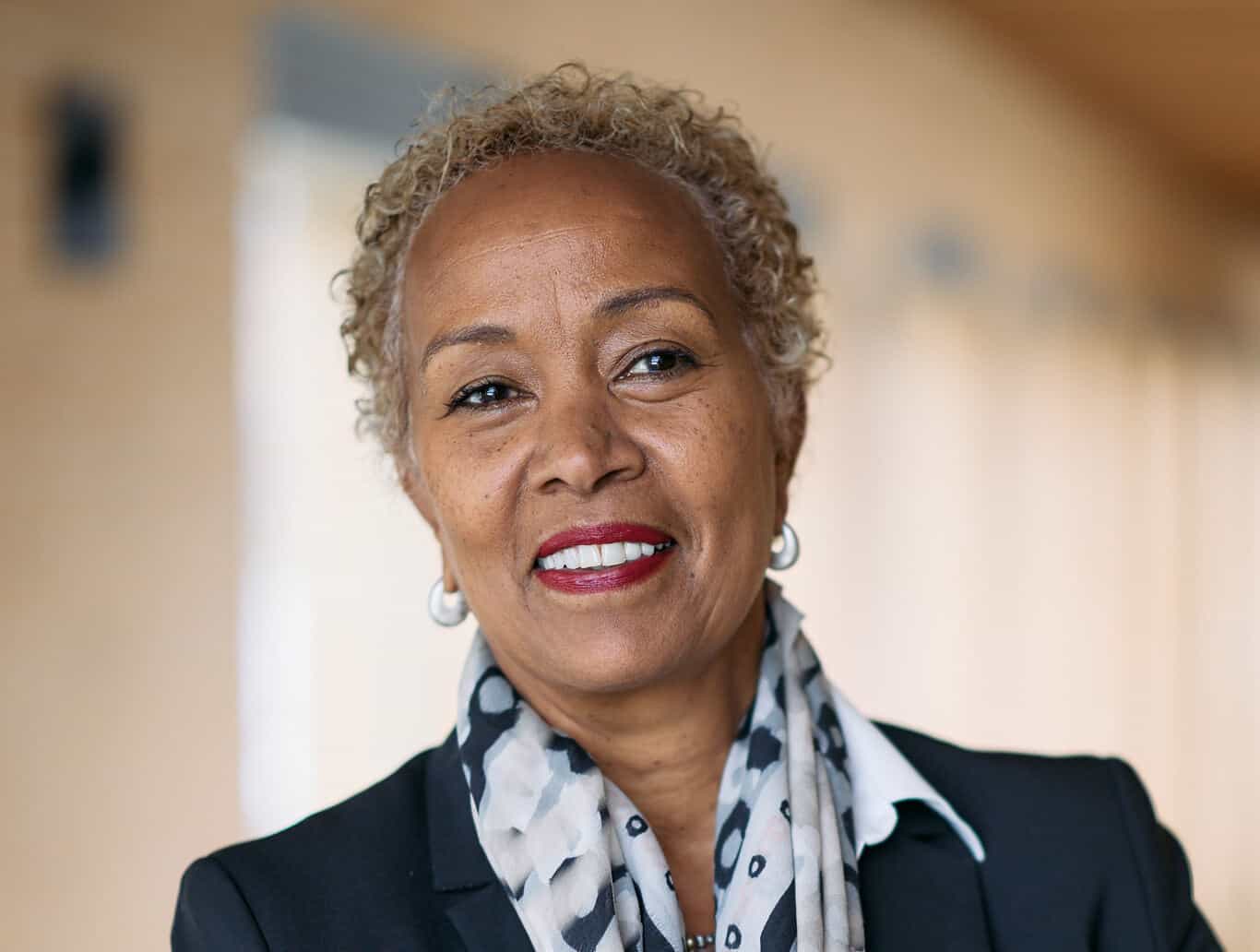 African woman smiling, advocating climate action and grants.