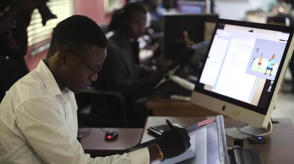Young African professionals working on digital devices in a modern office setting.