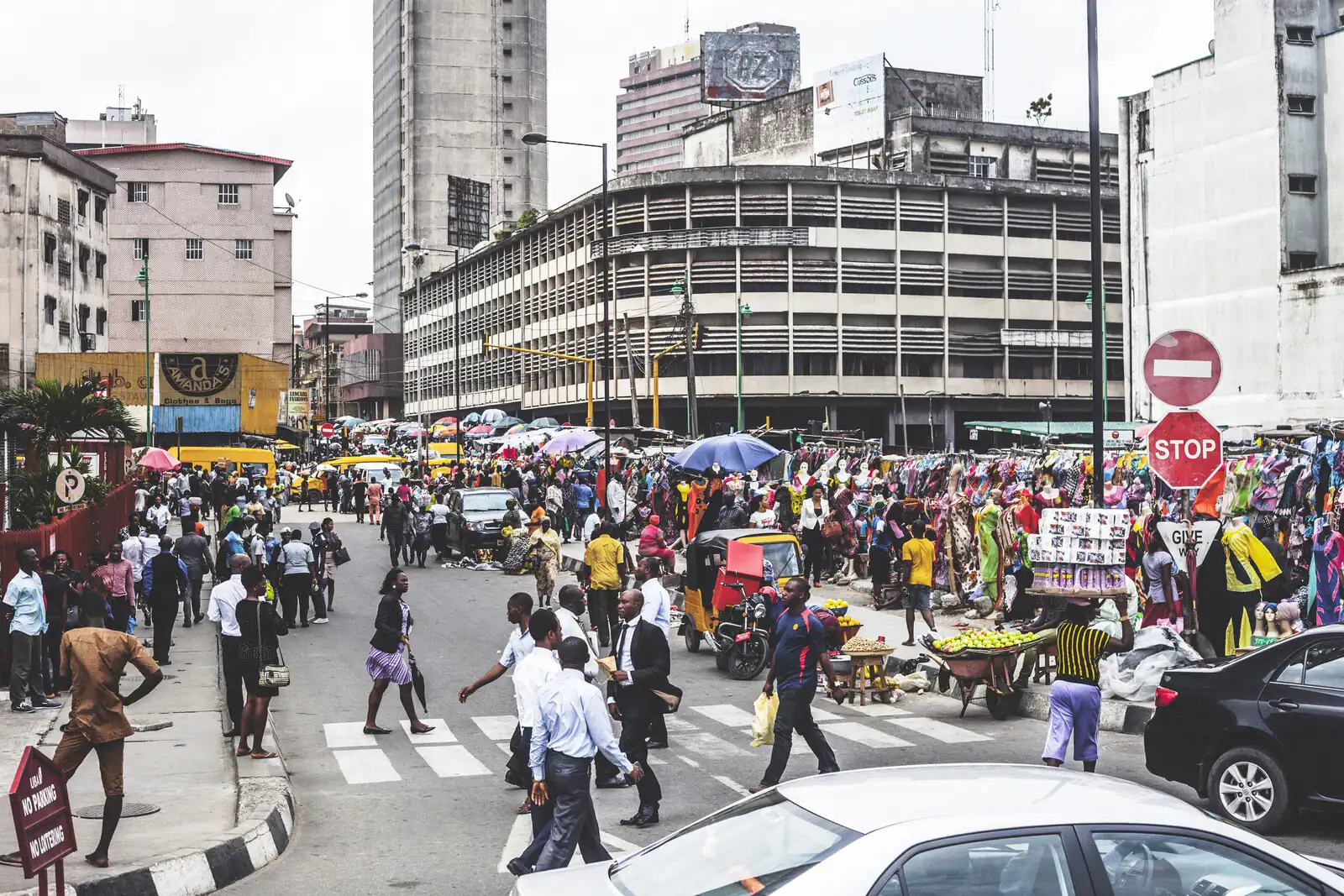 Vibrant African city street with crowds, vendors, and traffic reflecting economic activity.