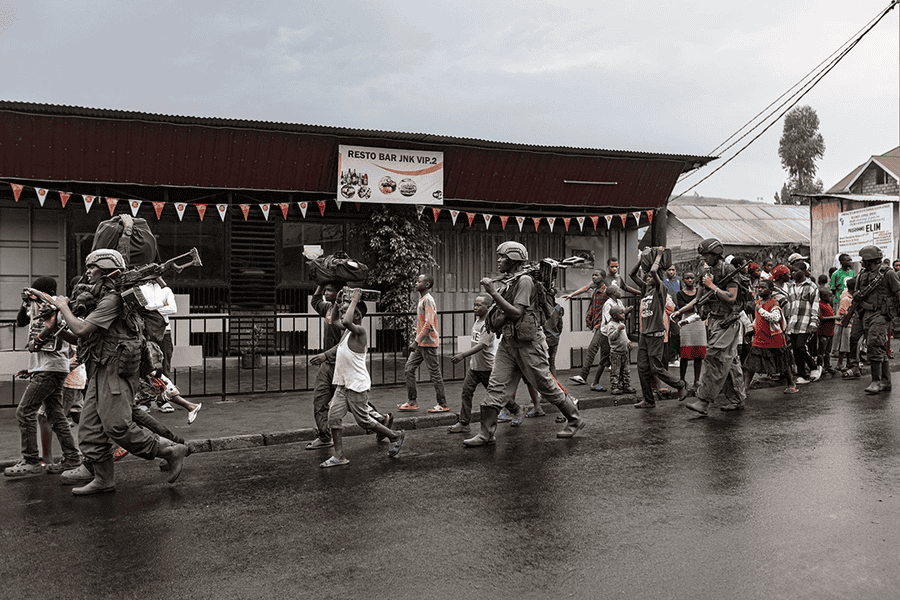 Soldiers and children in Goma during conflict, showing chaos and displacement.