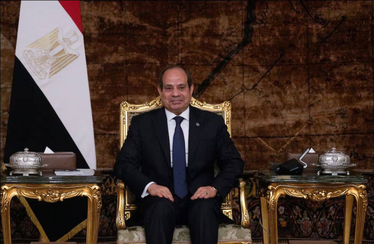 An official seated on a luxurious gold-trimmed chair in a formal office environment.
