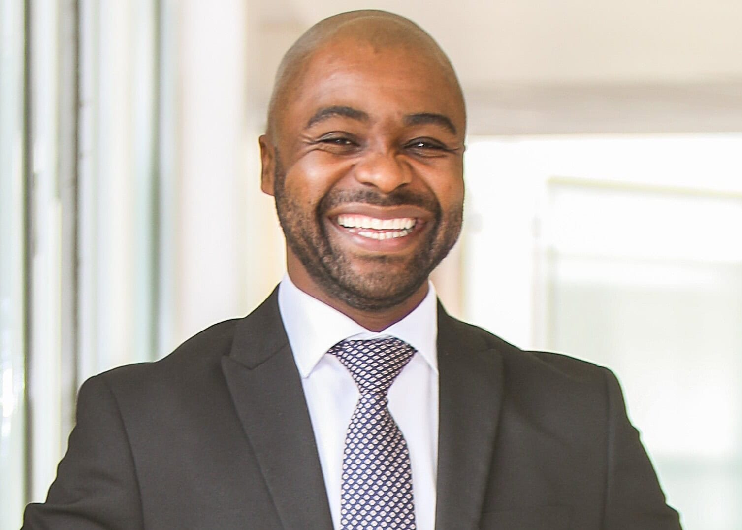 Smiling business professional in formal suit, representing Cape Town's economic growth.