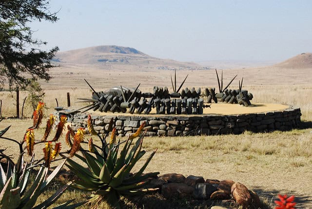 Historical African battlefield with traditional weapons display.