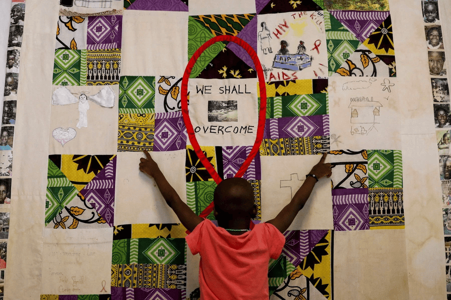 Child engaging in a mural emphasizing hope and overcoming challenges in Africa.