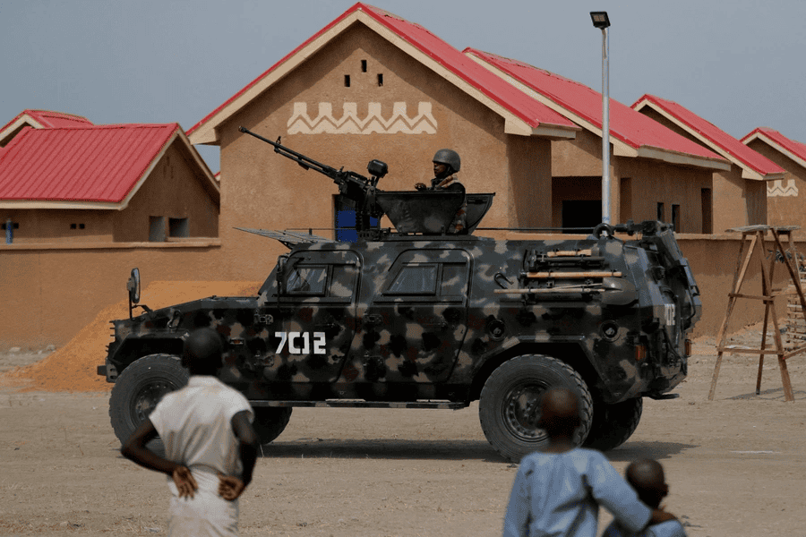 Armed soldier in a military vehicle patrolling a neighborhood in Africa.