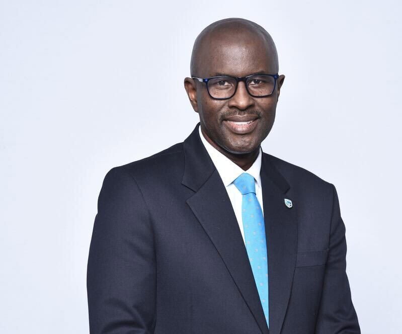 An African business leader in a formal suit and glasses, representing renewable energy initiatives i.