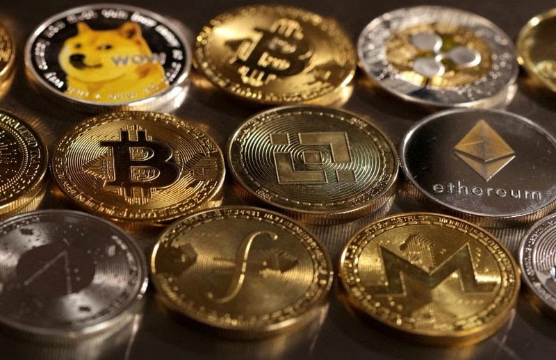 Cryptocurrency coins including Bitcoin, Ethereum, and Monero on a reflective surface.