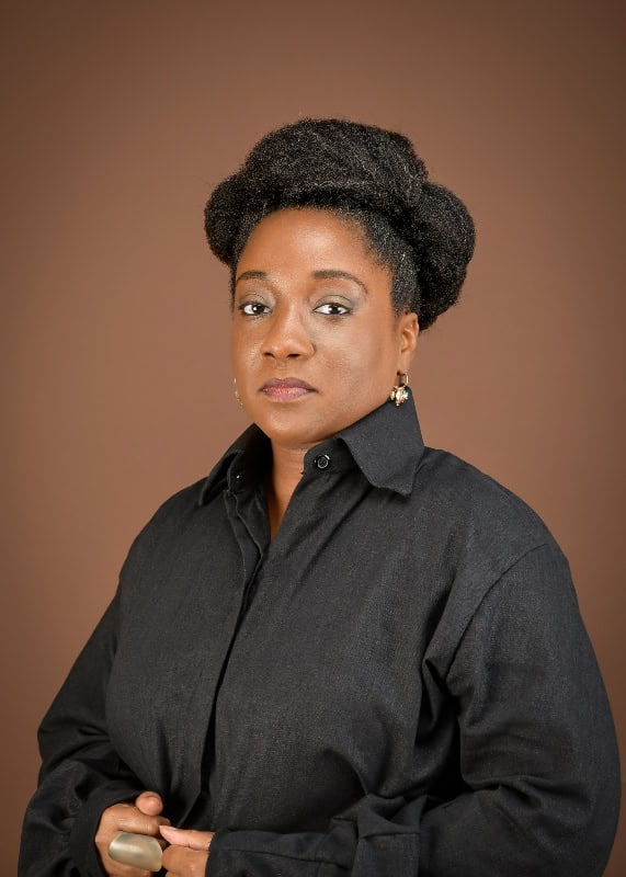 African woman in professional attire looking confident.