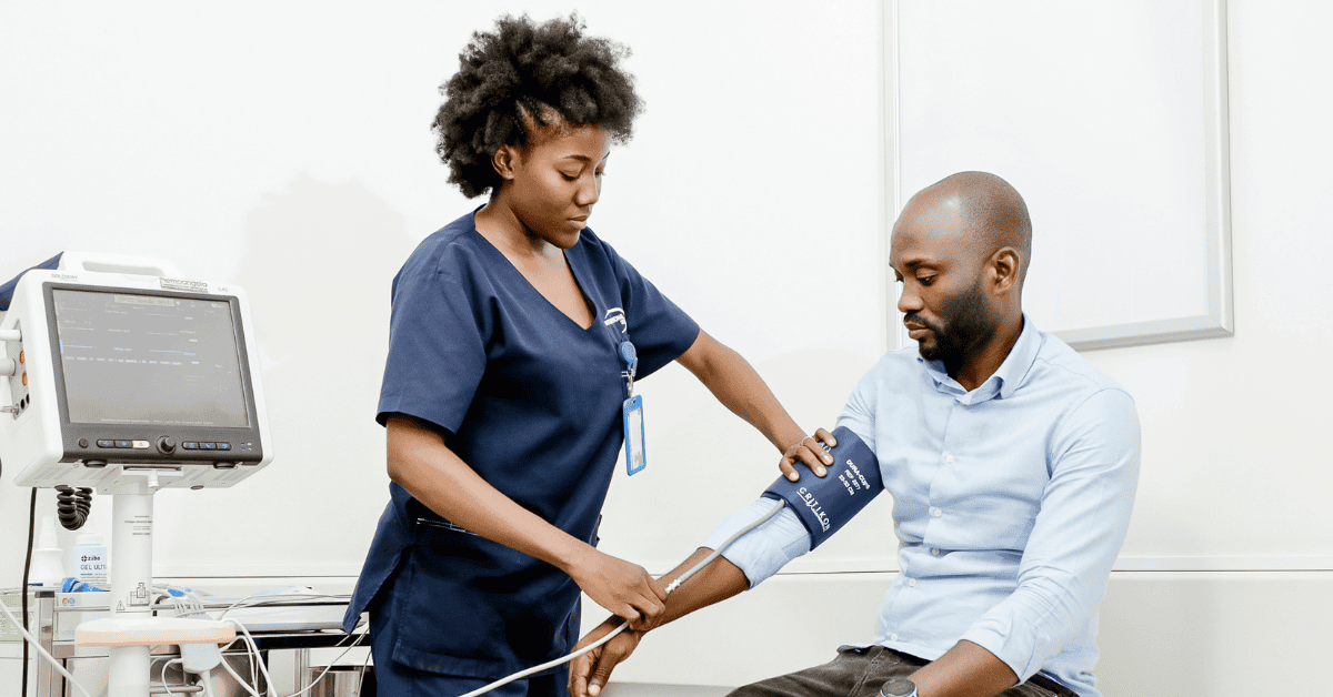 Healthcare professional measuring blood pressure of a patient in a clinical environment.