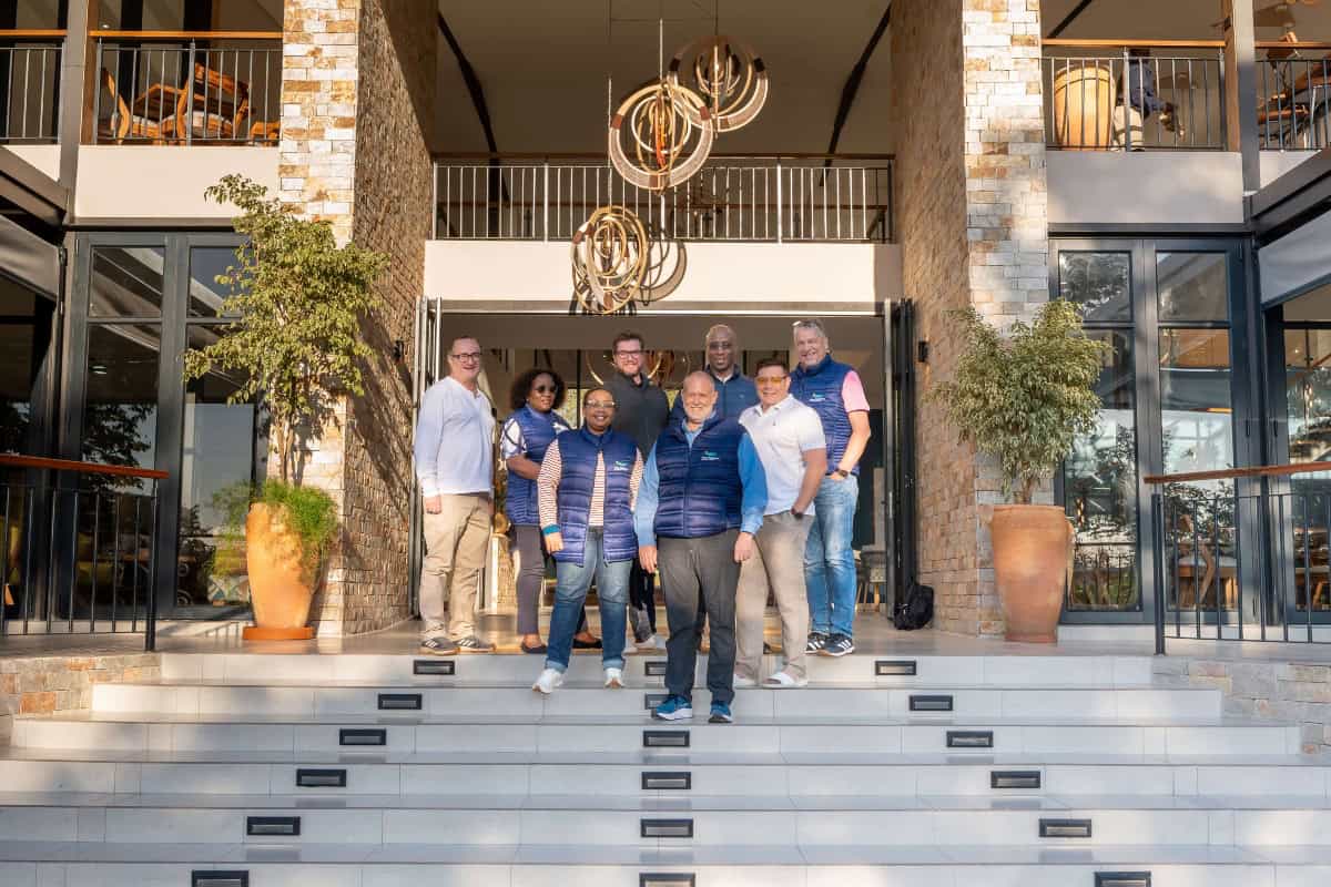 Beautiful group photo outside Waterfalls Lodge in Victoria Falls, showcasing sustainable tourism and.