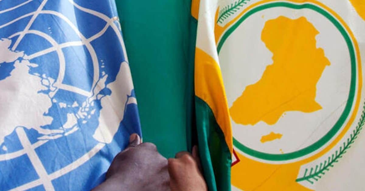 Hand holding African and United Nations flags symbolizing democracy and unity in Africa.