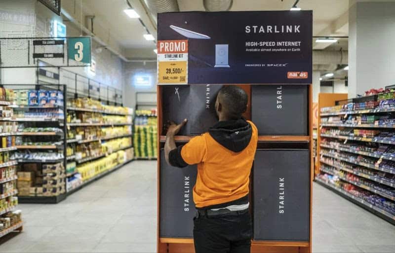 Person interacting with Starlink promotional display in a store aisle.