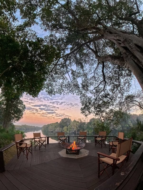 Scenic sunset view over Lolelunga Private Reserve with a cozy fire pit and seating area.