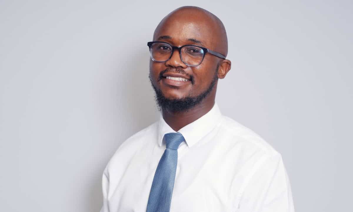 A professional man with glasses, dressed in a white shirt and tie, representing leadership in South.