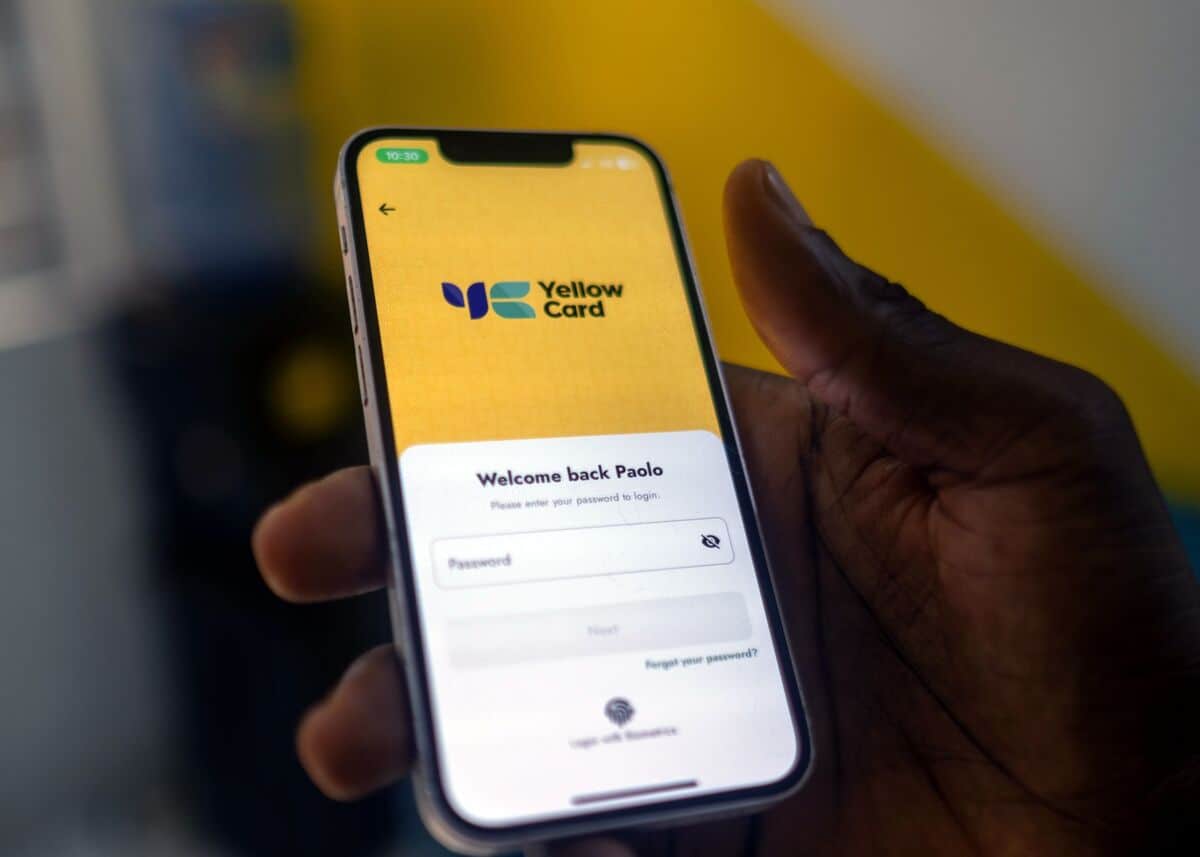 Mobile phone displaying Yellow Card stablecoin app in an emerging market setting.