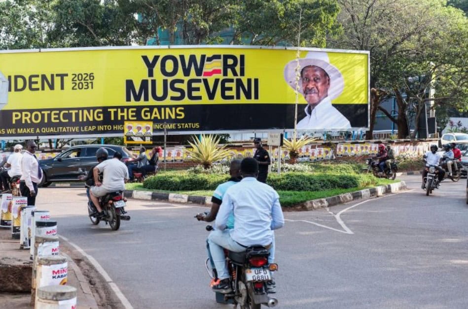 Campaign billboard of long-serving African leader in a busy city intersection.