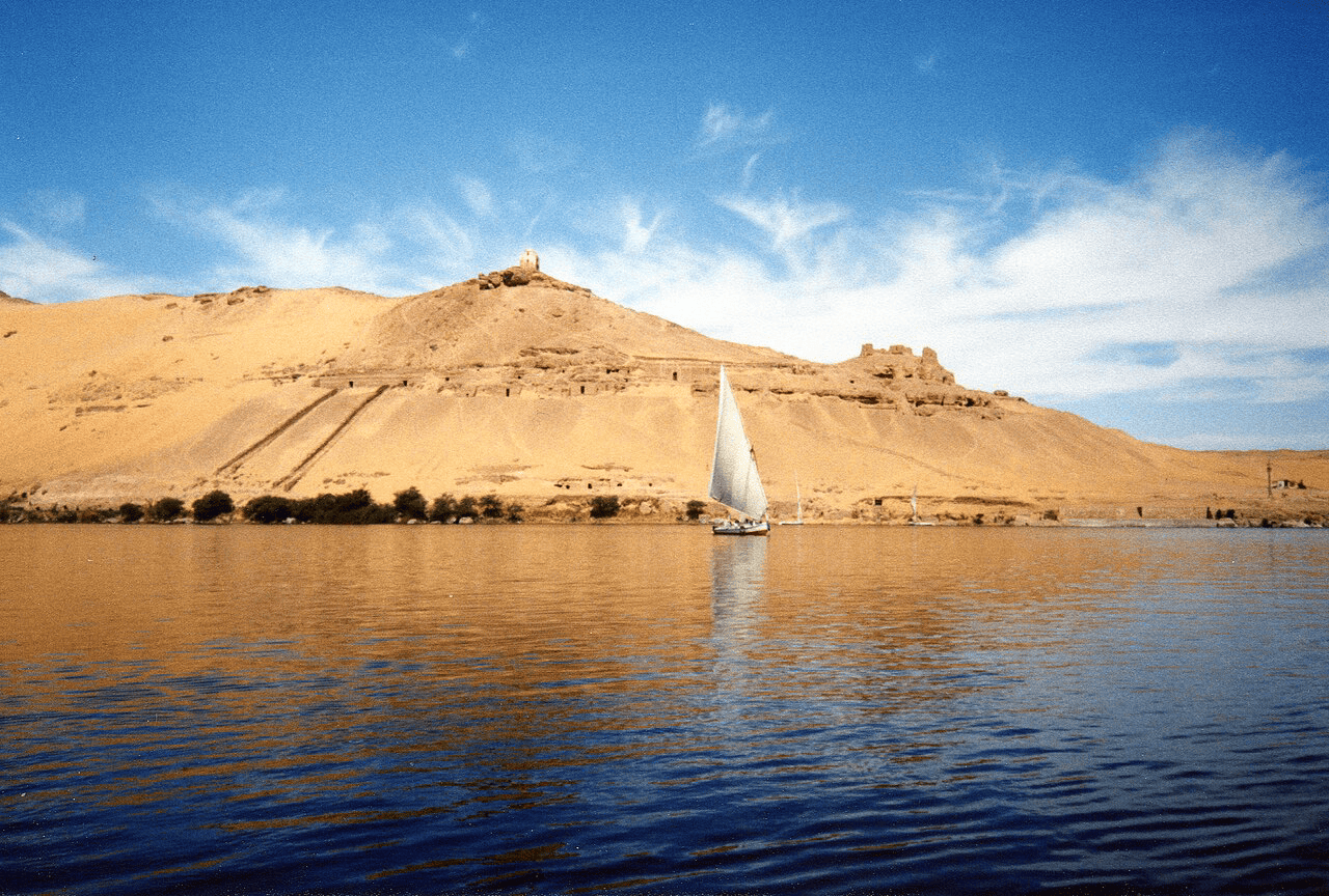 Scenic view of Lake Nile with sailboat and desert hills in Africa.