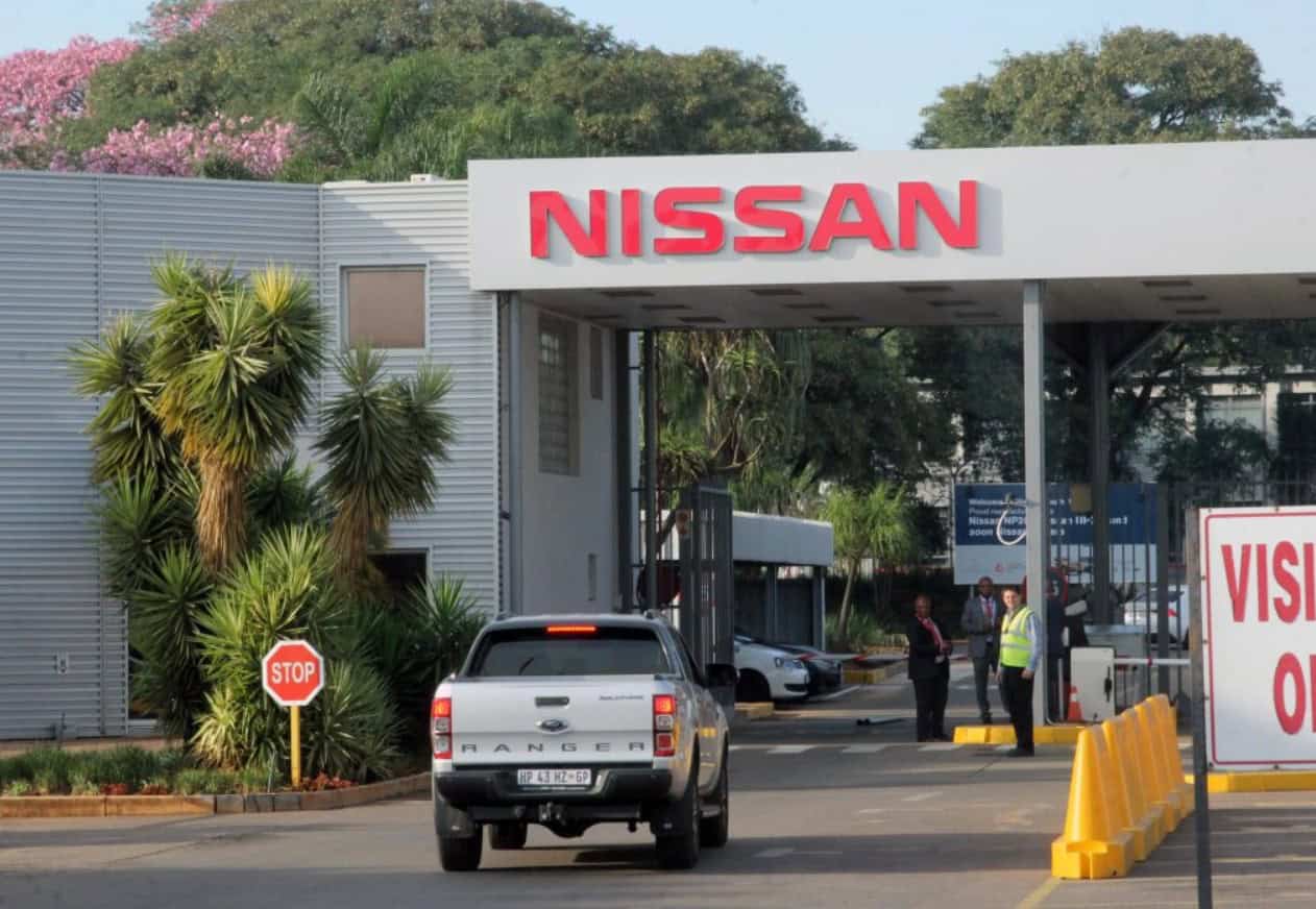 Nissan dealership entrance with cars and staff in Africa, promoting automotive industry growth.