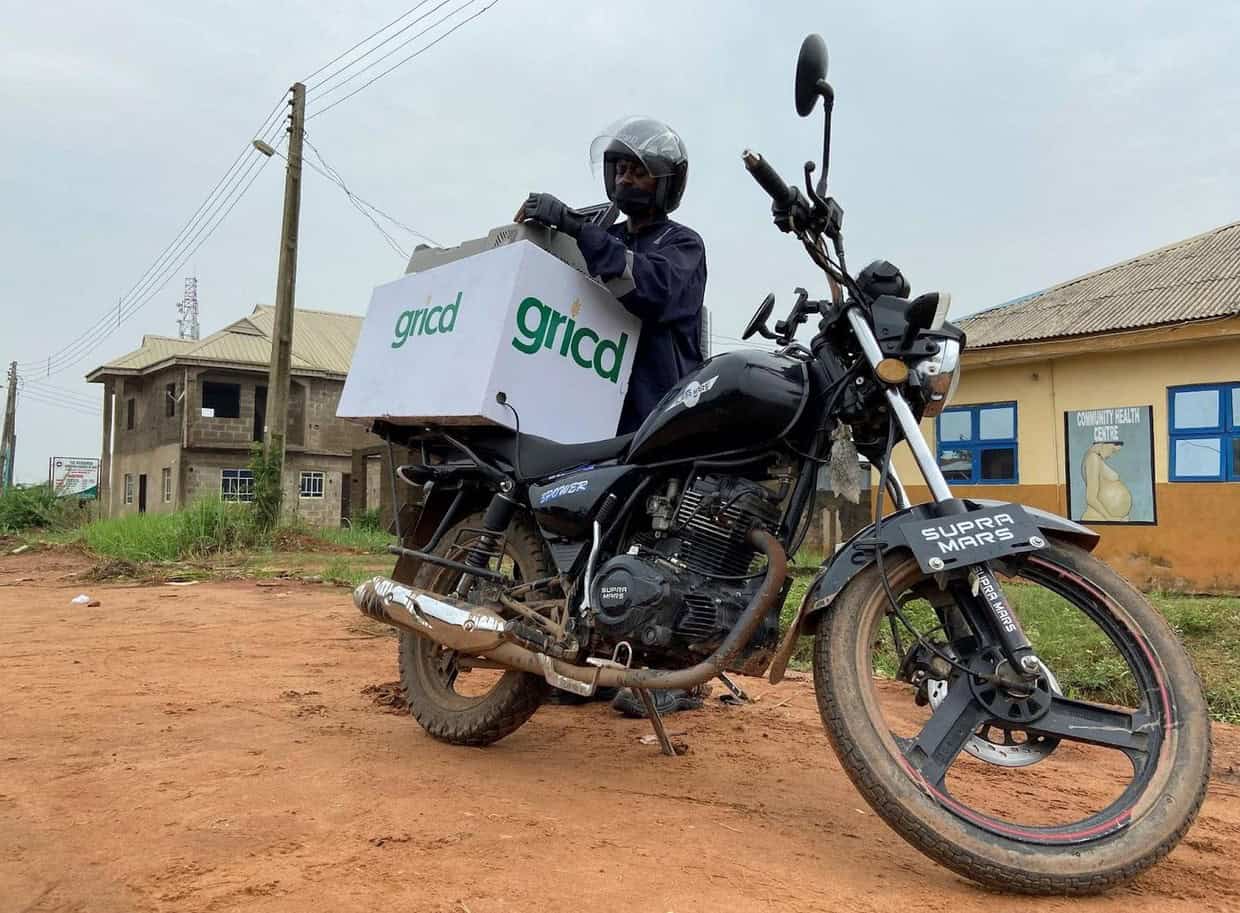 Rural African delivery rider with Gricd-branded motorcycle for startup logistics.