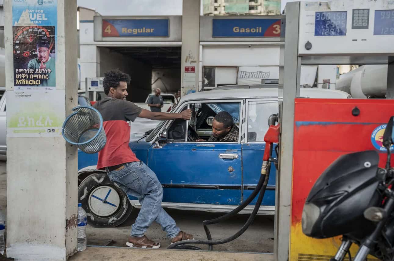 Ethiopian man refueling an electric vehicle at a charging station in Ethiopia.